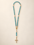 Full blue quartz rosary on warm ivory background with the gold-tone baguette CZ cross
