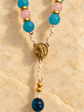 Close-up of the Bliss rosary Marian center and rounded gold disc spacers