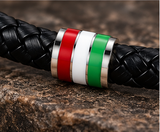 Close-up of stainless steel flag bead on black braided leather bracelet