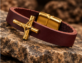 Gold PVD plated crucifix stainless steel on maroon leather bracelet close-up
