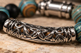 Close-up styled photo of curved metal centrepiece and beaded texture