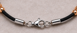 Close-up of Ebedi polished steel bracelet clasp, cord and rose gold IP beads
