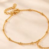 Detail of adjustable clasp and round bead accents on gold-plated hand chain