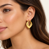 Gold IP stainless steel angular hoop earring worn by a model