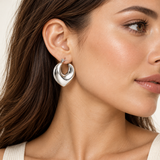 Silver stainless steel angular hoop earring worn by a model