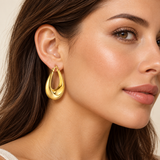 Gold IP stainless steel elongated hoop earring worn by a model