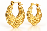 Close-up of ornate gold IP stainless steel hoop earrings